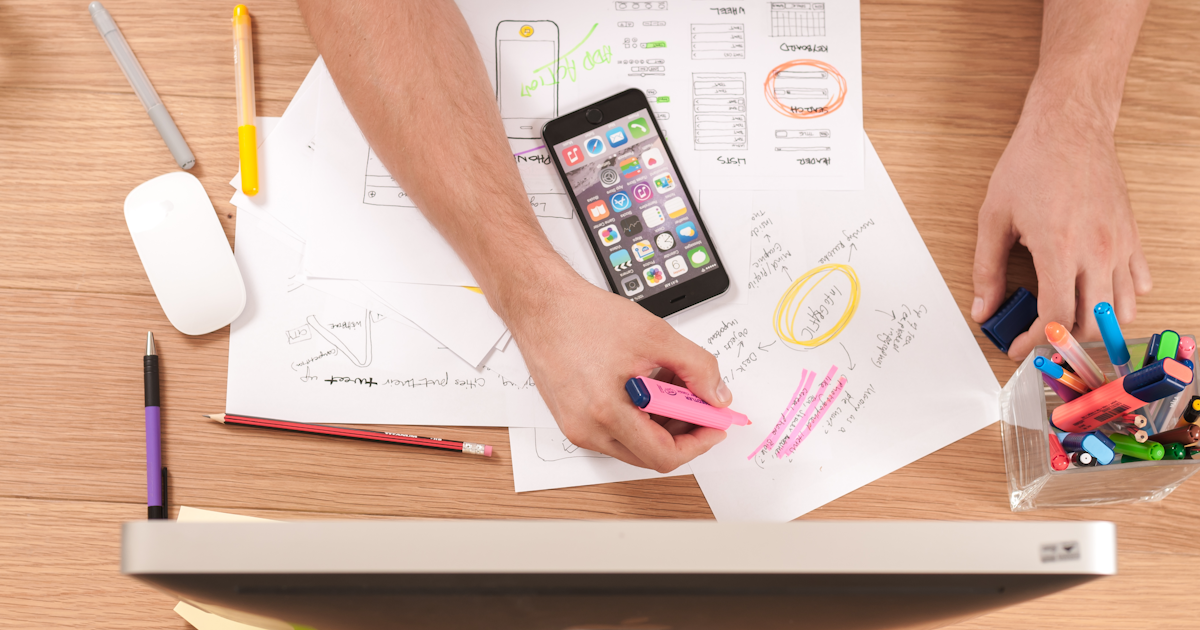 Creator designing social media graphics alongside a content scheduling calendar on dual monitors